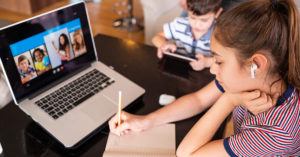 Teenage girl studying with video online lesson at home family in isolation Homeschooling and distance learning