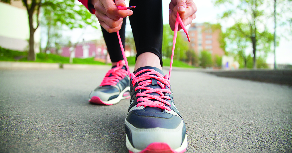 Female hands lacing running shoes. Closeup