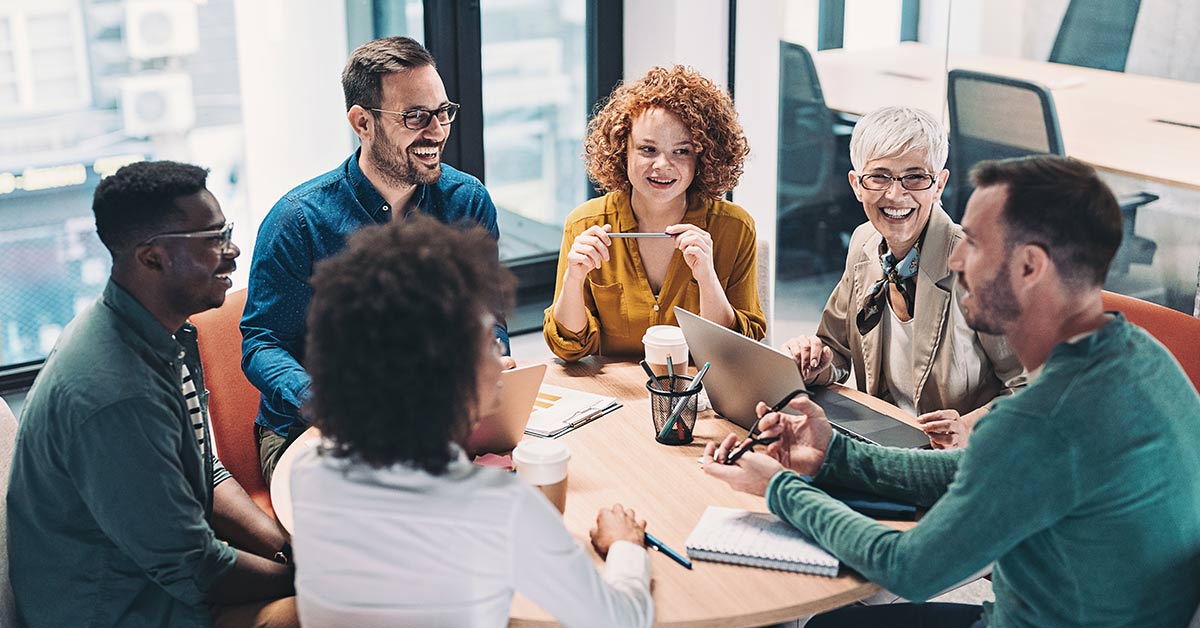 Mixed group of business people sitting around a table and talking