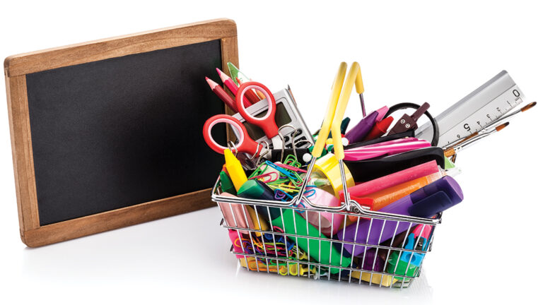 Back-to-School Shopping Shopping basket filled with school supplies isolated on white background
