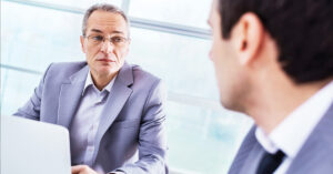 Two businessman in a meeting. Focus is on the mature man.