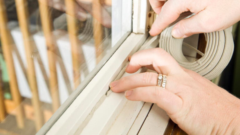 Blog Featured Image – Reduce Summer Cooling Costs Hands Applying Weather Seal Caulk to Window Frame