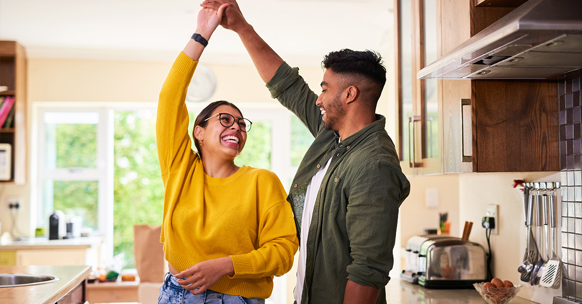 Shot of a young couple dancing together in their kitchen