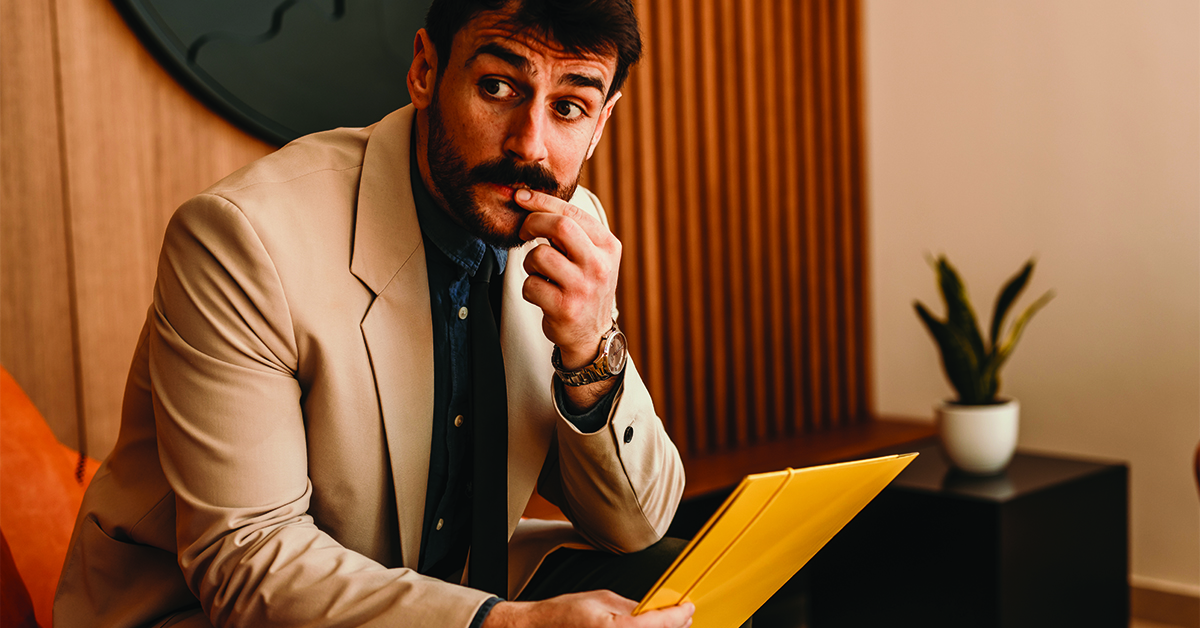 A nervous male candidate waiting for the human resource team for a job interview in the office.