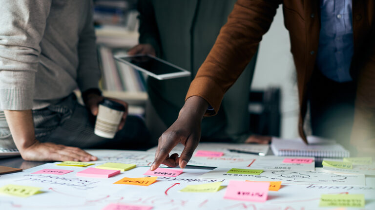 Blog Featured Image_Falling Forward Problem-Solving Techniques Close-up of creative people working on new business project and analyzing mind map on paperboard.