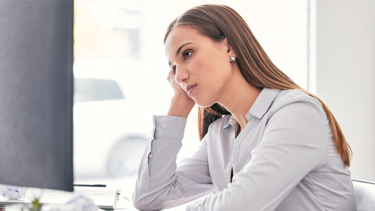 Helping a Team Member Get Back on Track Shot of an attractive young businesswoman sitting alone in the office and feeling bored while using her computer