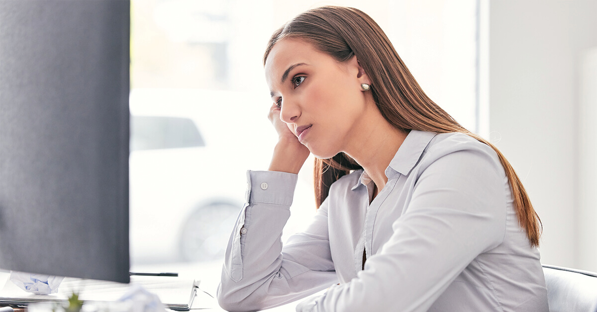 Shot of an attractive young businesswoman sitting alone in the office and feeling bored while using her computer