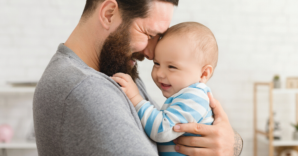 Loving father embracing his cute baby son