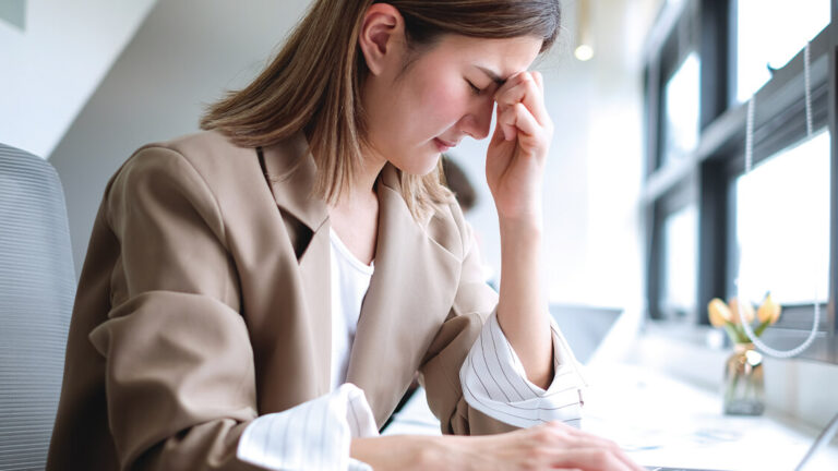 Providing Support During Troubling Times Asian businesswoman stressed while working long hours using laptop in office