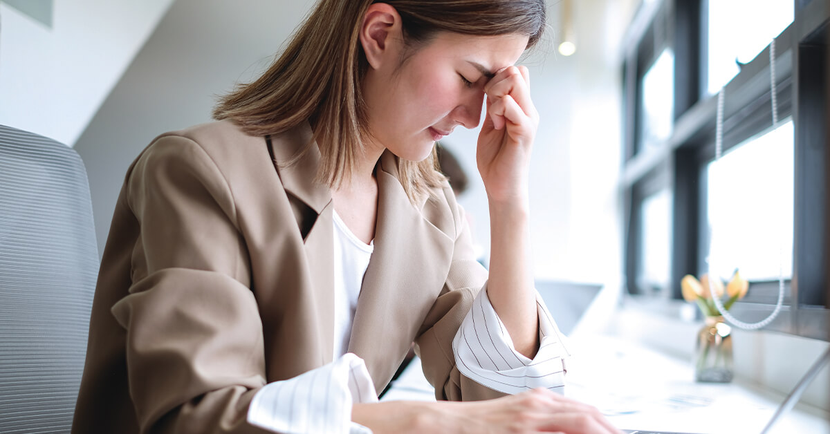 Asian businesswoman stressed while working long hours using laptop in office