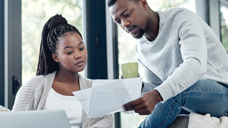 Creating a Spending Plan Shot of a young couple going through paperwork at home