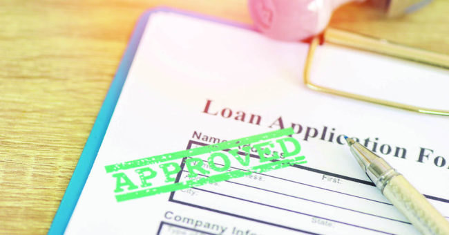 Emergency-Expenses Loan approval, Loan application form with Rubber stamping that says Loan Approved, Financial loan money contract agreement company credit or person.