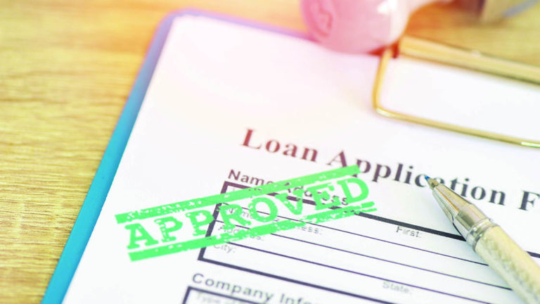 Emergency-Expenses Loan approval, Loan application form with Rubber stamping that says Loan Approved, Financial loan money contract agreement company credit or person.