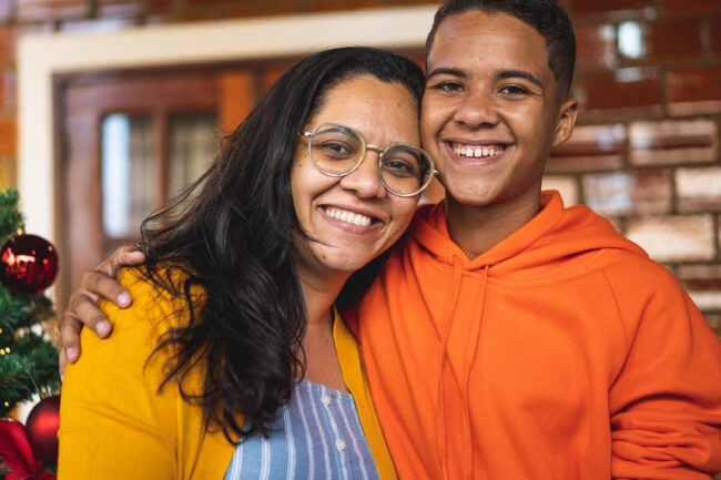 Featured Blog Image: Family Conflict and the Holidays Two family members hugging and diffusing family Conflict and the Holidays