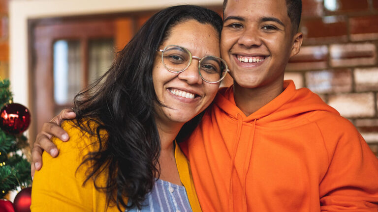 Featured Blog Image: Family Conflict and the Holidays Two family members hugging and diffusing family Conflict and the Holidays