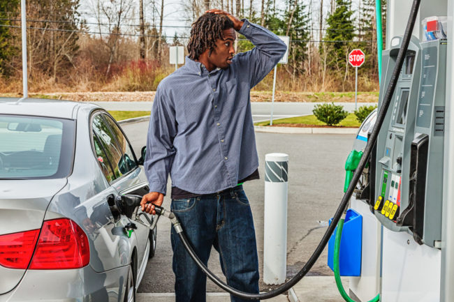 Young Man at Gas Station in Shock Over Sale Price man frustrated pumping gas