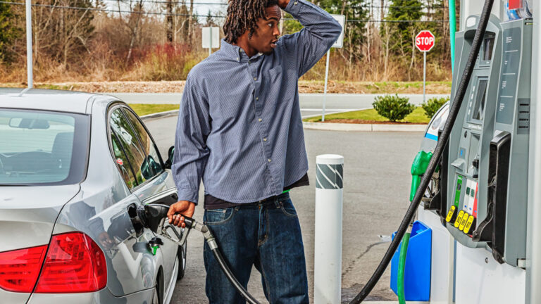 Young Man at Gas Station in Shock Over Sale Price man frustrated pumping gas