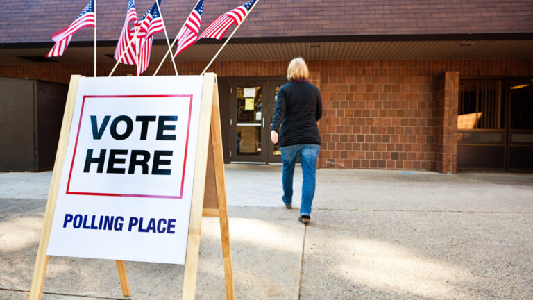 Woman Voter Entering Voting Polling Place for USA Government Election voting signage outside of polling building