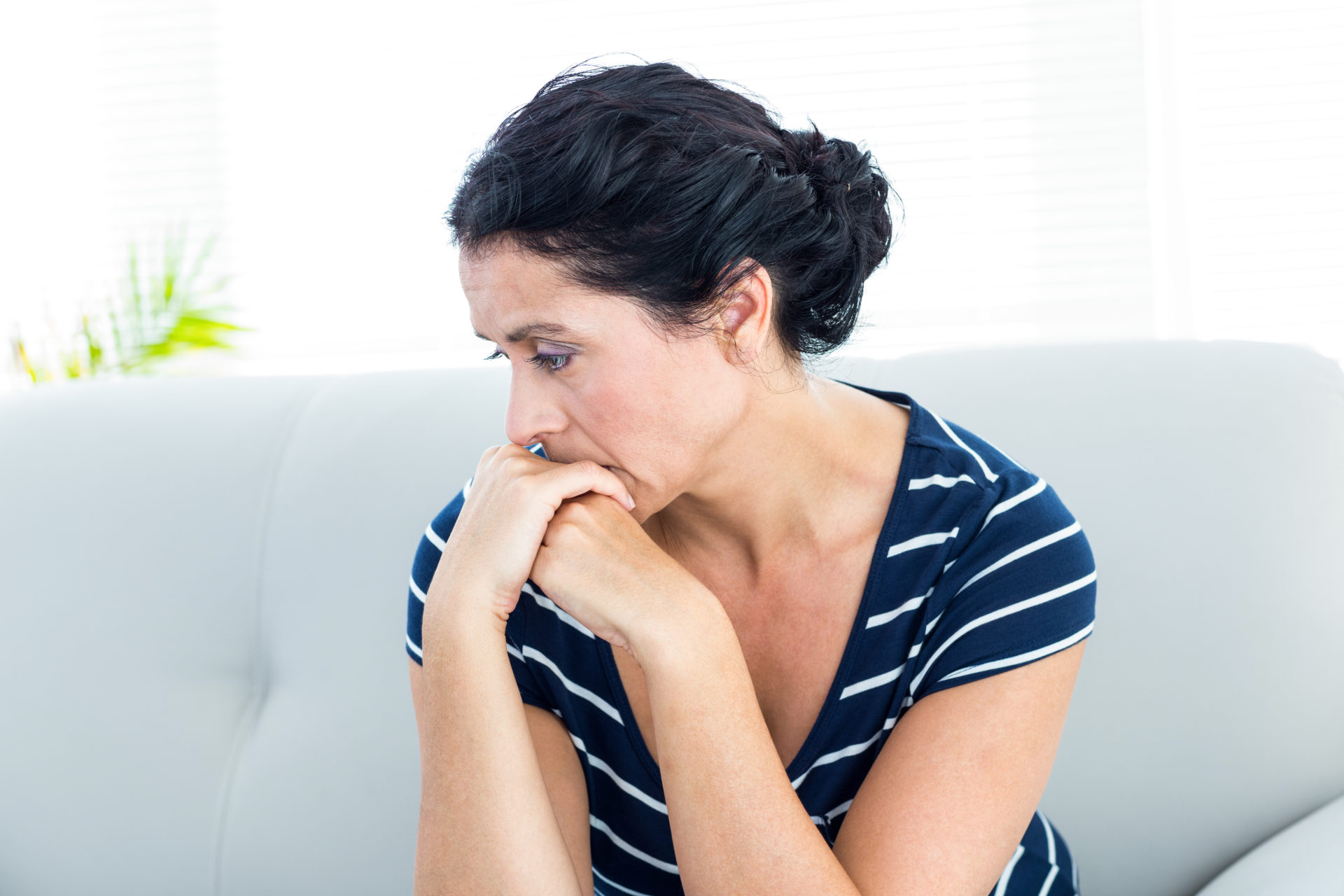 woman looking depressed on a couch