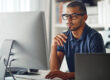 Cropped shot of a businessman using his computer in his home office