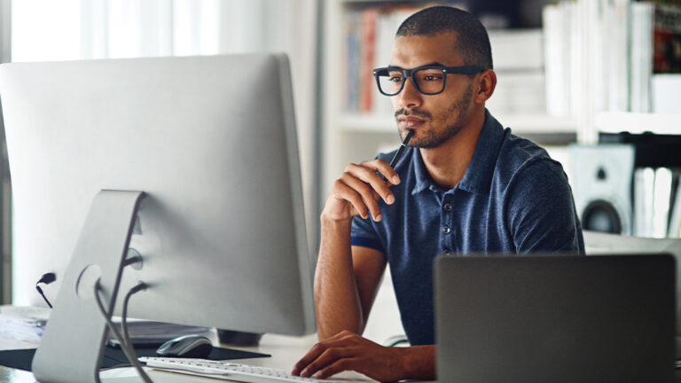 Maintaining Focus Cropped shot of a businessman using his computer in his home office
