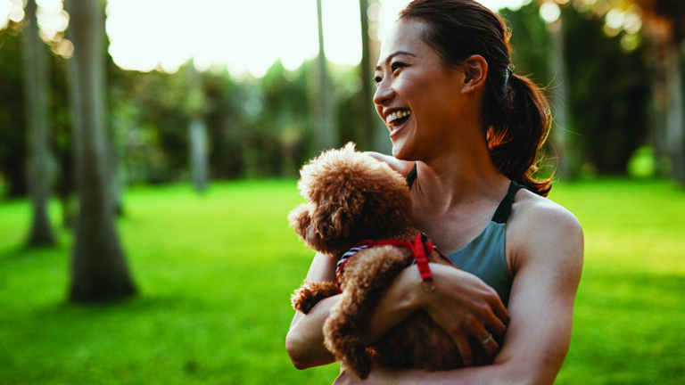 Maintaining Your Emotional Wellbeing Beautiful Taiwanese sport woman with dog in the park