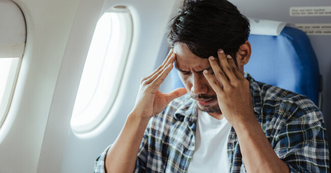 Featured-Image-Episode 47-Afraid to Fly An airplane passenger sits tensed and afraid in his seat