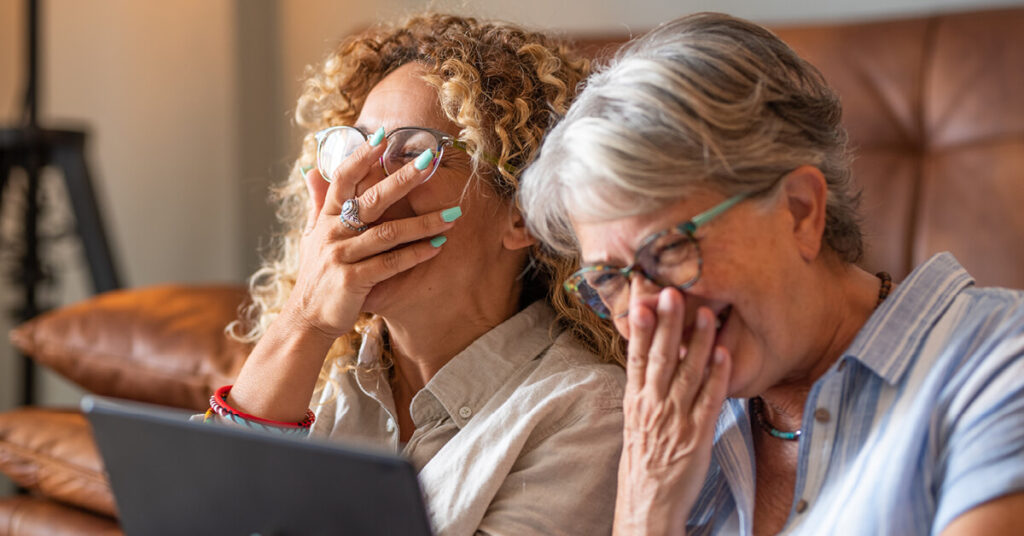 Friends laughing together while watching videos on social media
