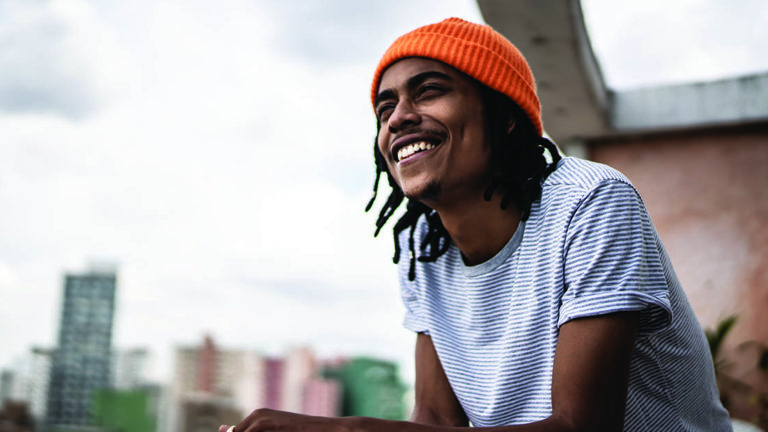 Realistic-Optimism Young man contemplating in the apartment's porch