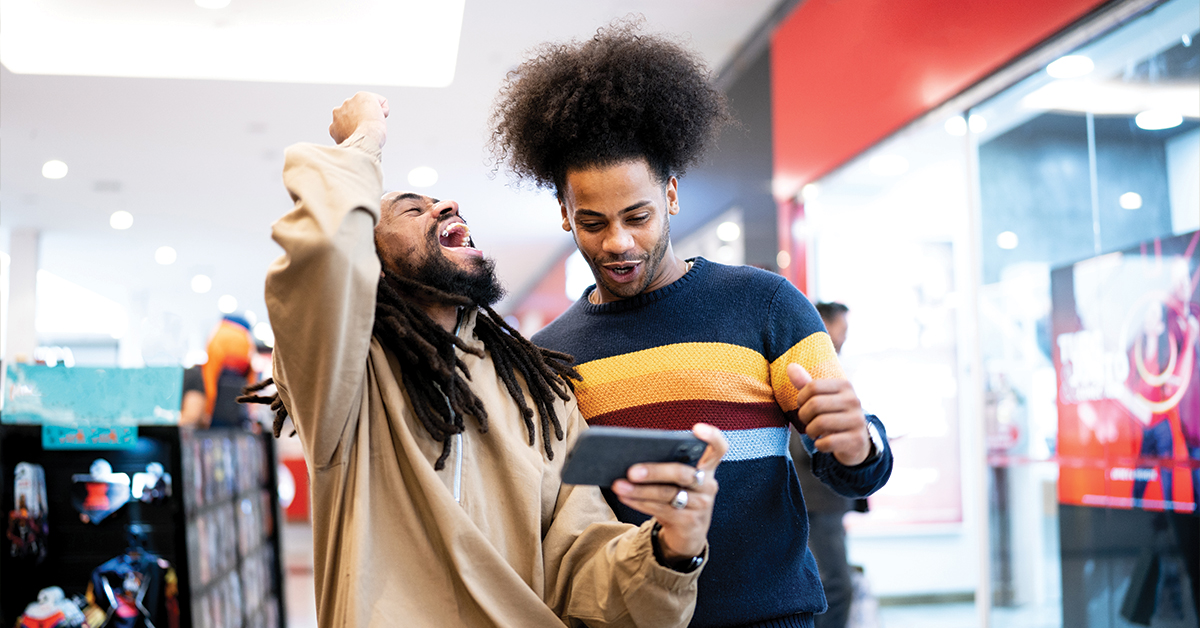 Brothers watching sports or playing on the smartphone at the mall