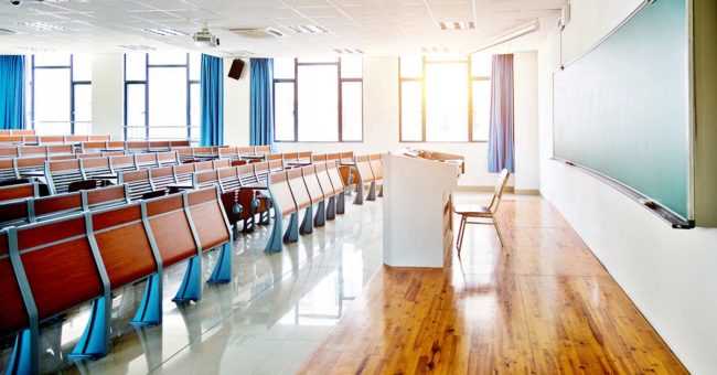 Students-Coping-With-Change-During-COVID-19 Desks and chairs in a lecture hall