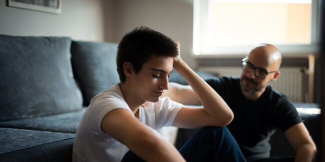 Survivor and Family Assistance Upset young man talking with his father.