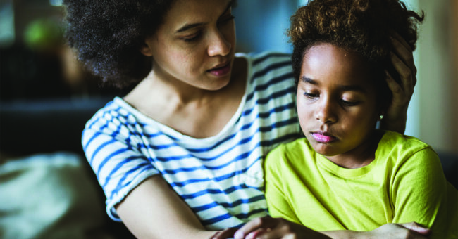 Talking to Children About Violence African American mother consoling her sad girl at home.