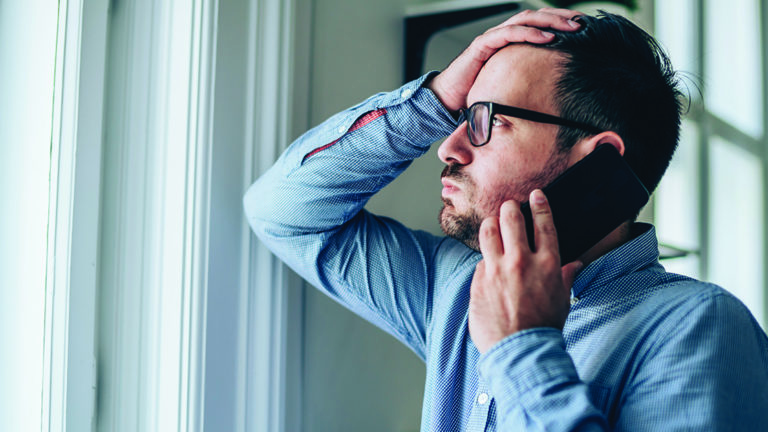 anxious-safety-signals-featured-images Worried businessman with hand on forehead talking on mobile phone in his office.