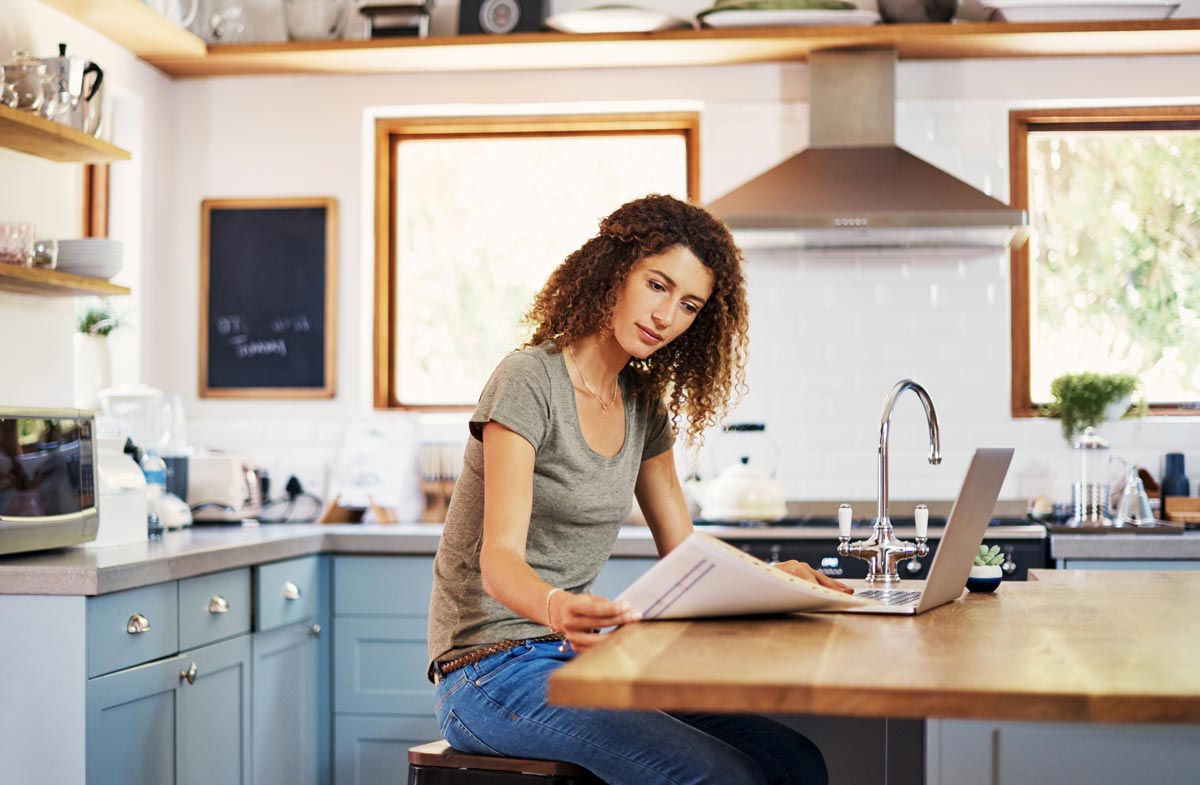 Woman sitting at a kitchen island working on her laptop