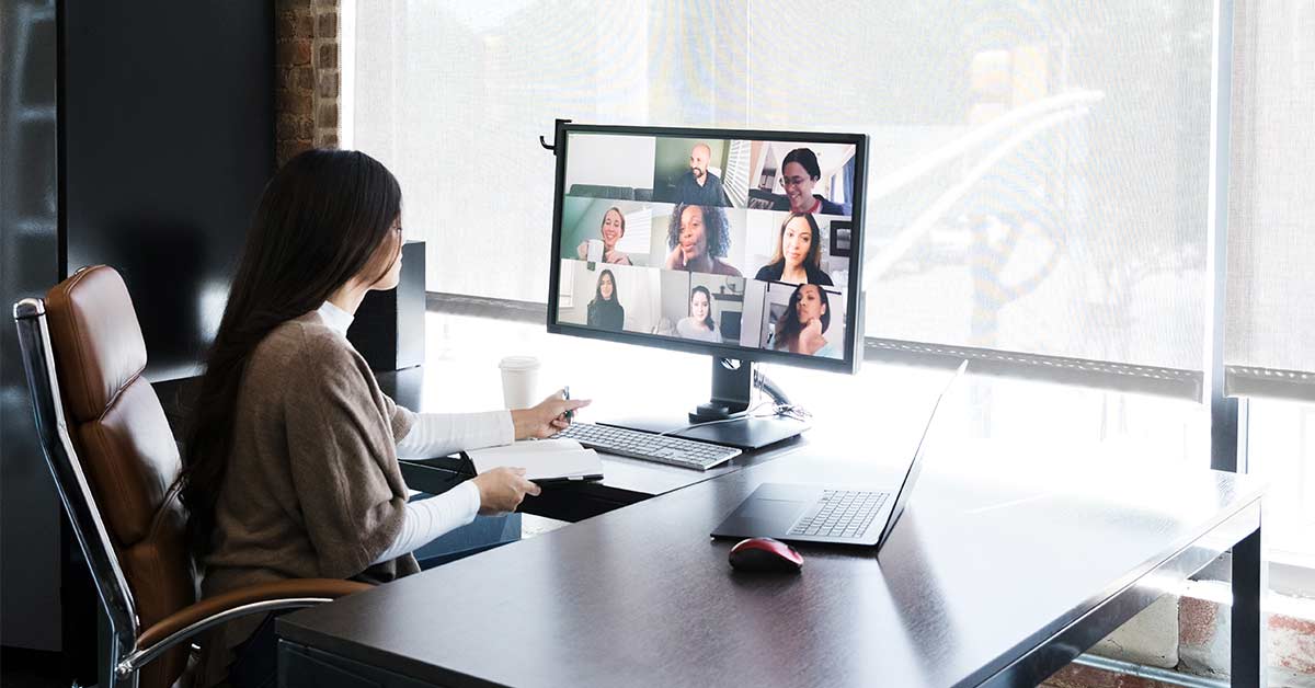 covid-blog-empathy A group of creative professionals meet virtually to discuss and brainstorm ideas. A young female creative professional is working in an office while talking with colleagues who are telecommuting from their homes.