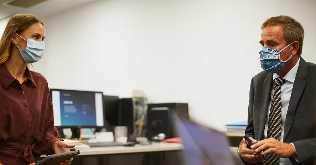 Business office, people at work. Wearing a protective mask.