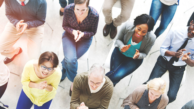 employee-assistance-programs Group of employees seated at a meeting clapping