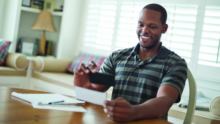 financial-wellness-checkup-featured-image A man using his smartphone to deposit his check