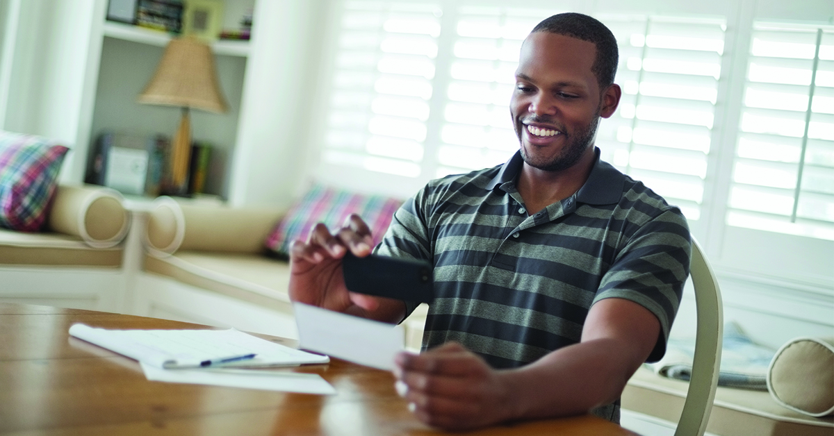 financial-wellness-checkup-featured-image A man using his smartphone to deposit his check