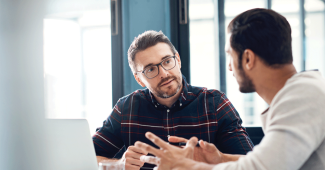giving-feedback-featured-image Shot of two businessmen having a discussion in an office