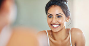 Cropped of an attractive young woman looking at her face in the bathroom mirror