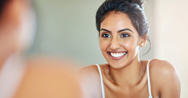 mindful-moments-sink-featured-image Cropped of an attractive young woman looking at her face in the bathroom mirror