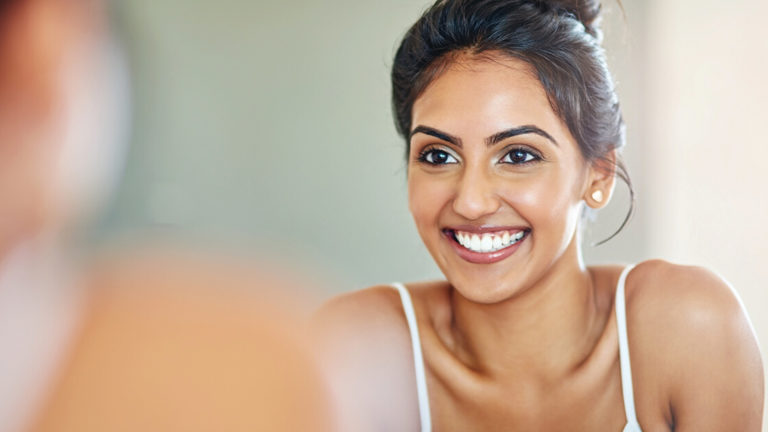 mindful-moments-sink-featured-image Cropped of an attractive young woman looking at her face in the bathroom mirror