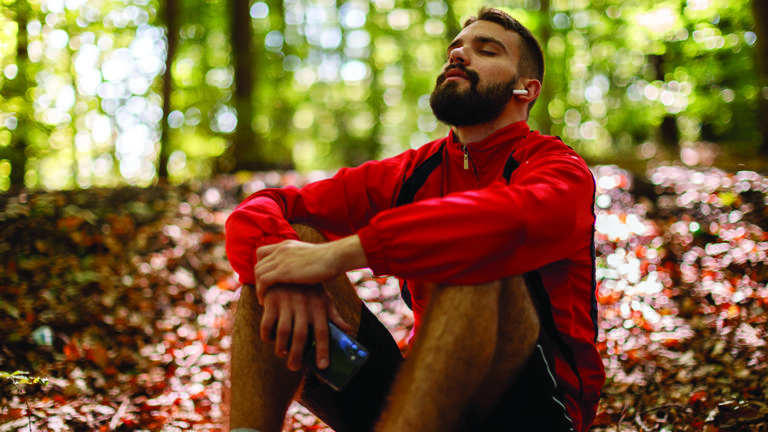 nature-immersion-featured-image Portrait of relaxed young man with bluetooth headphones in forest