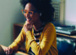Working from home in the era of the new normal: a happy mixed race woman attending an online meeting.