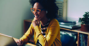 Working from home in the era of the new normal: a happy mixed race woman attending an online meeting.