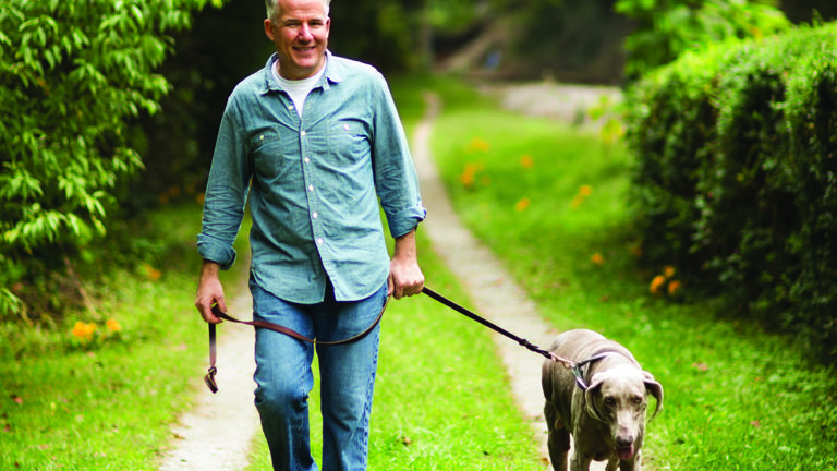 perspective-matters-featured-image Mature man walking in park with his pet Labrador Retriever.