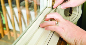 Hands Applying Weather Seal Caulk to Window Frame