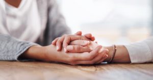 Closeup shot of two unrecognisable people holding hands in comfort